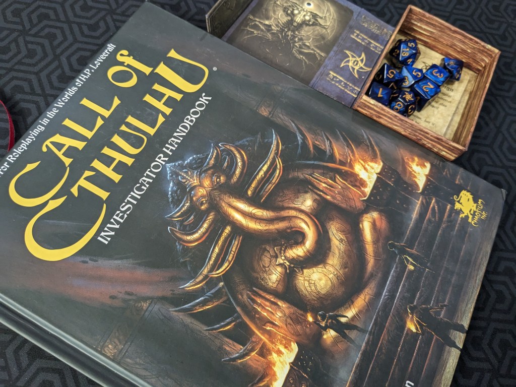 The Call of Cthulhu Investigator Handbook next to a pack of dice.
